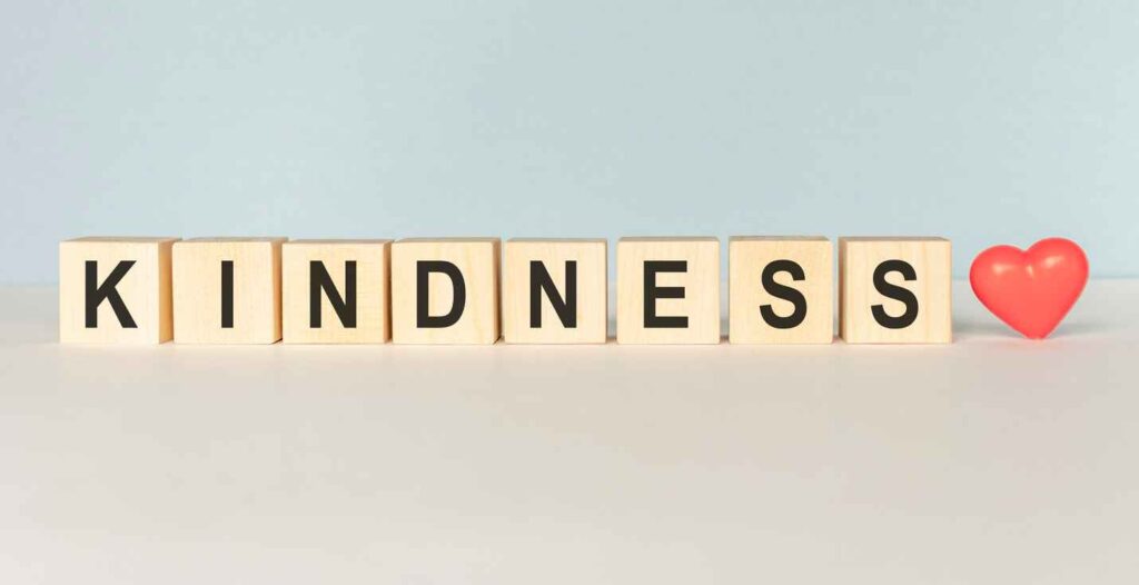 Kindness Word Written In Wooden Cube on a light background